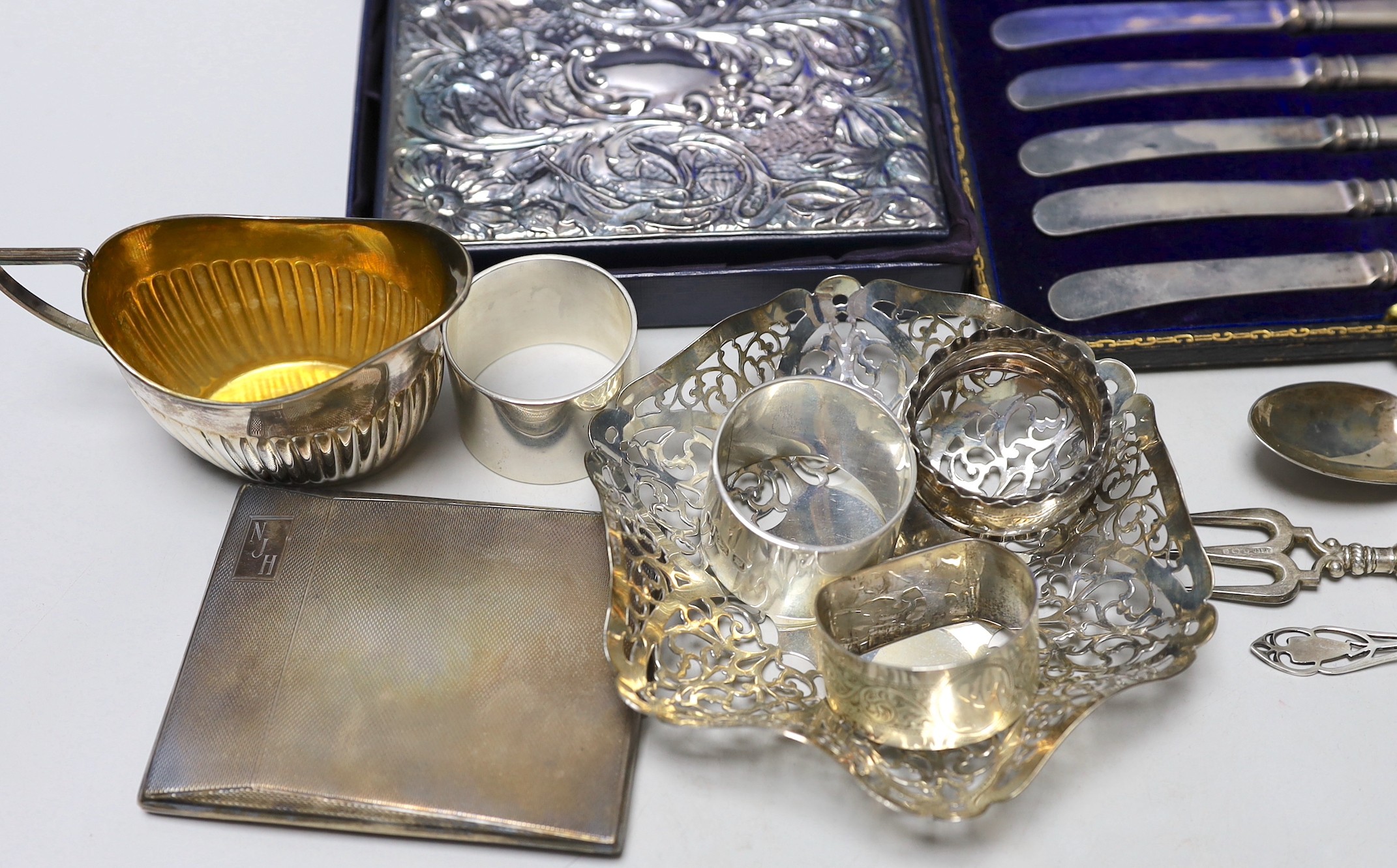 Sundry silver items including pierced shallow dish, cased handled tea knives, sterling mounted diary, cigarette case, seven napkin rings, cream jug and three items of cutlery.